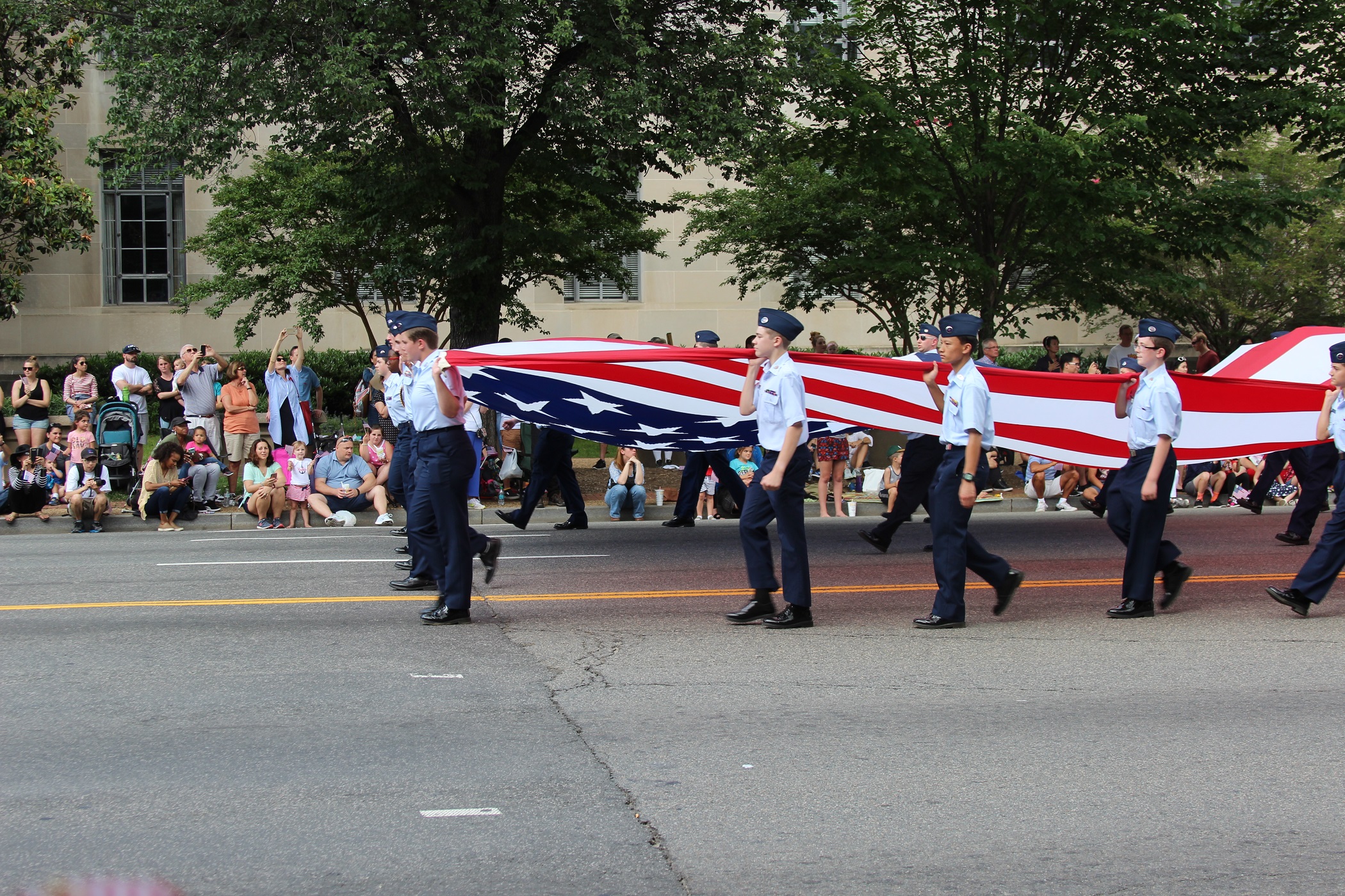 A group of people in uniform carrying an american flag.